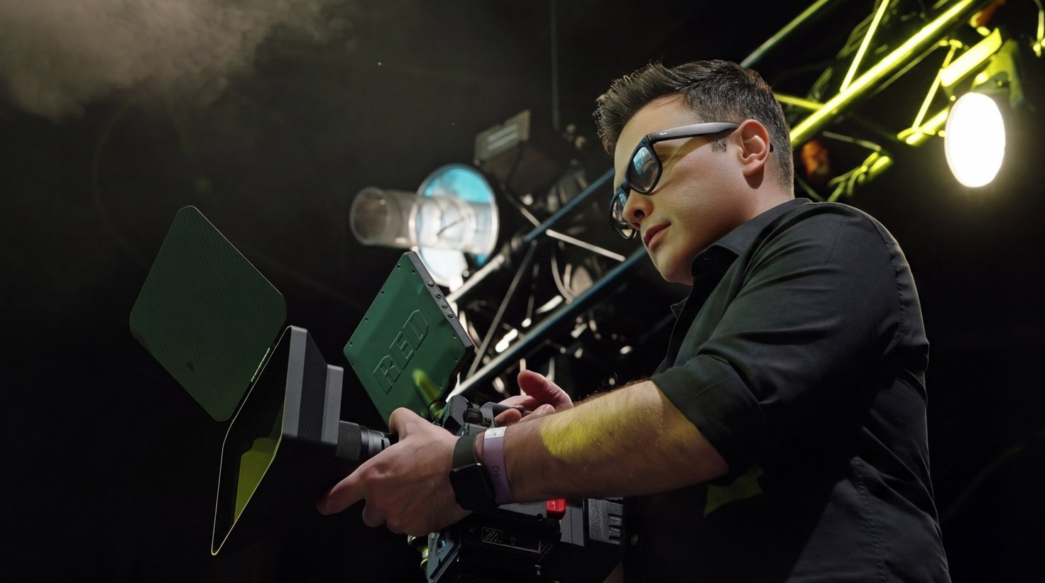Pixer cinematographer operating a professional cinema camera on stage with dramatic stage lighting
